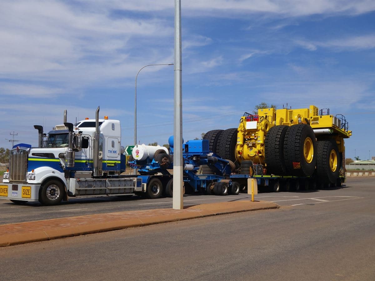 A heavy haul tractor and lowboy trailer carrying an oversized mining vehicle